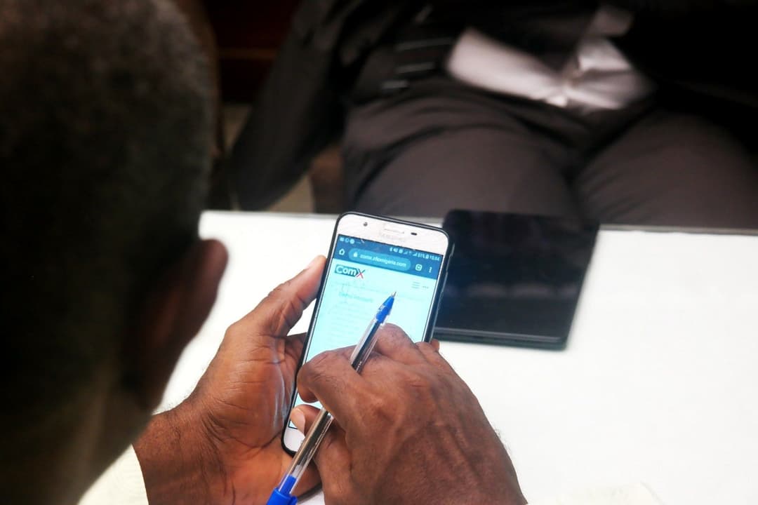 man_holding_a_pen_using_comx_on_his_phone.jpeg